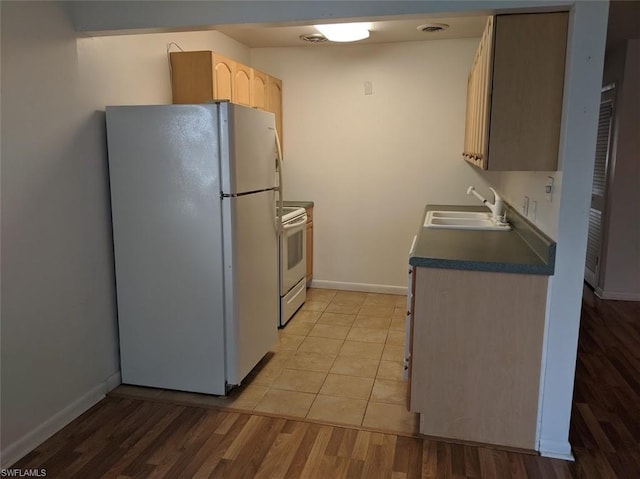 kitchen with light tile floors, light brown cabinetry, white appliances, and sink