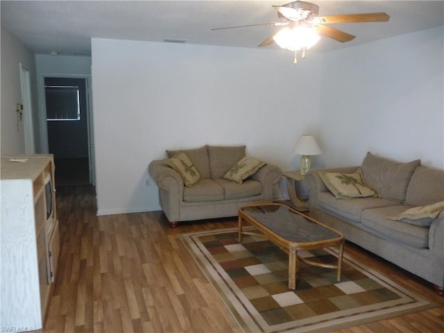 living room featuring hardwood / wood-style floors and ceiling fan