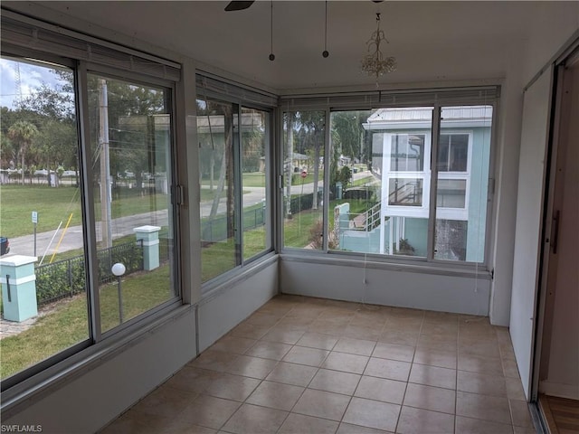 unfurnished sunroom with plenty of natural light and ceiling fan