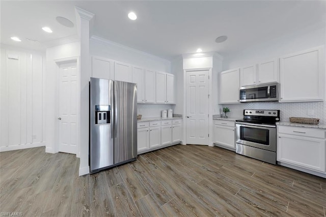 kitchen with white cabinetry, wood-type flooring, and appliances with stainless steel finishes