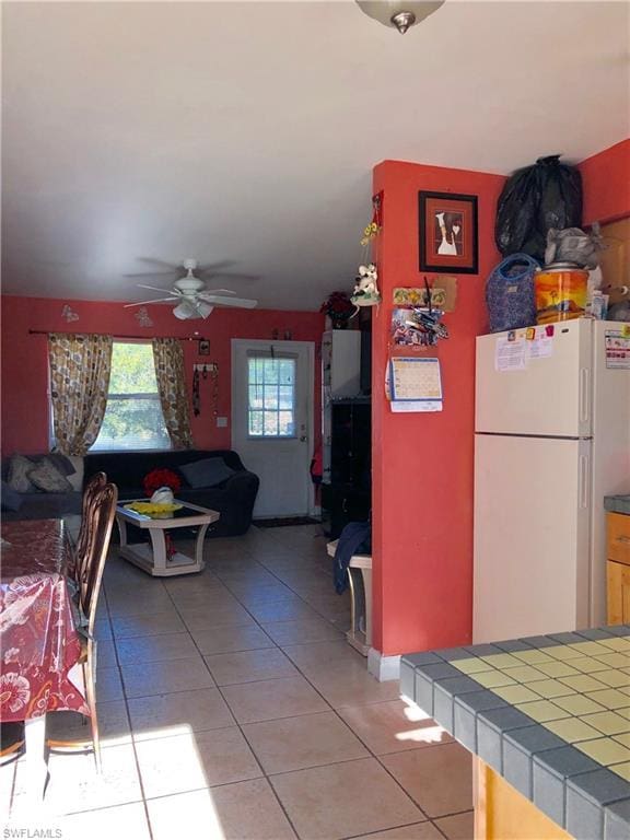 interior space with light tile flooring and ceiling fan