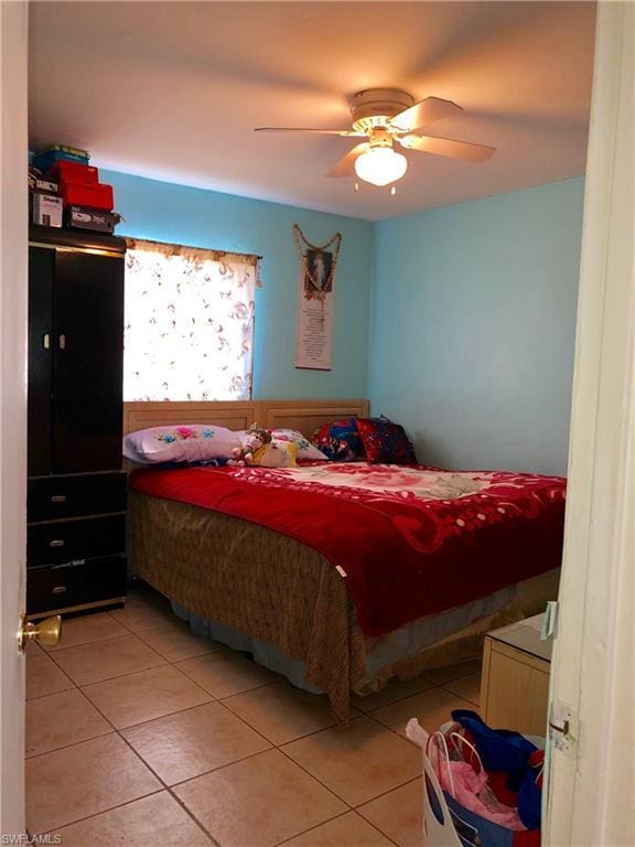 tiled bedroom featuring ceiling fan