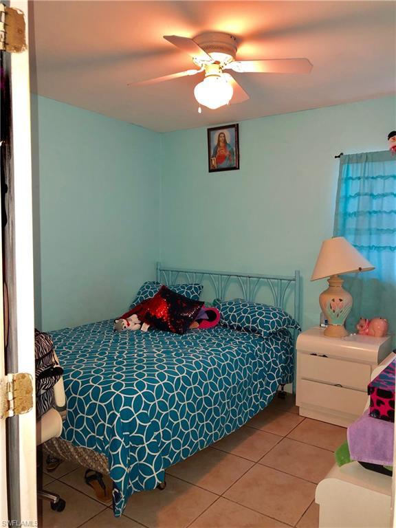 bedroom with light tile floors and ceiling fan