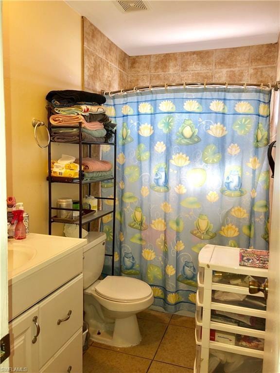 bathroom with vanity, tile floors, and toilet