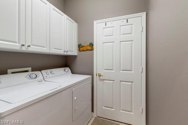 laundry area with cabinets and washer and clothes dryer