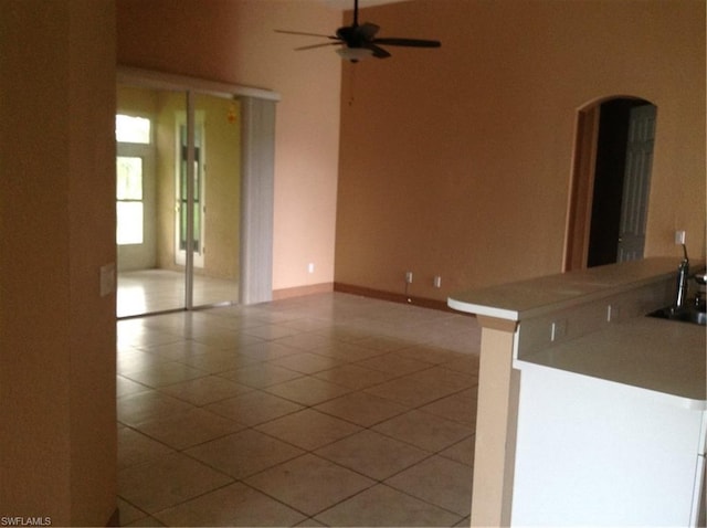 interior space featuring ceiling fan, light tile floors, and sink