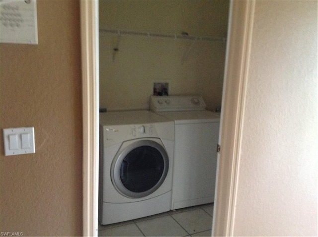 washroom featuring washer and dryer and light tile floors