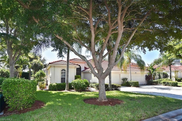 mediterranean / spanish home featuring a front lawn and a garage