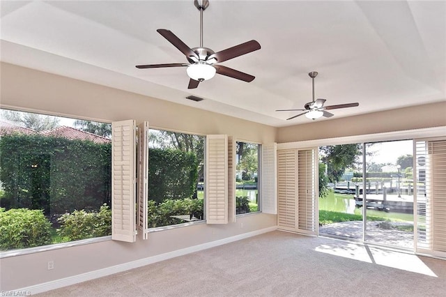 spare room featuring ceiling fan, a healthy amount of sunlight, and light colored carpet