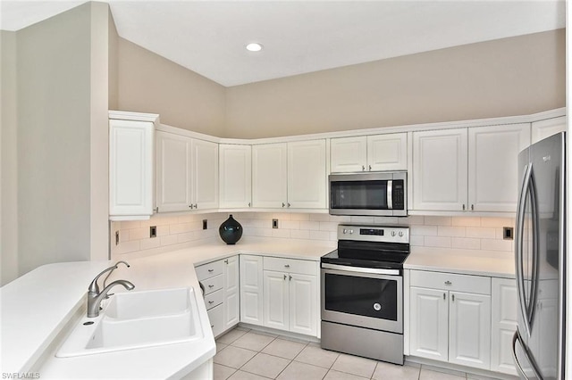 kitchen with white cabinets, tasteful backsplash, appliances with stainless steel finishes, and sink