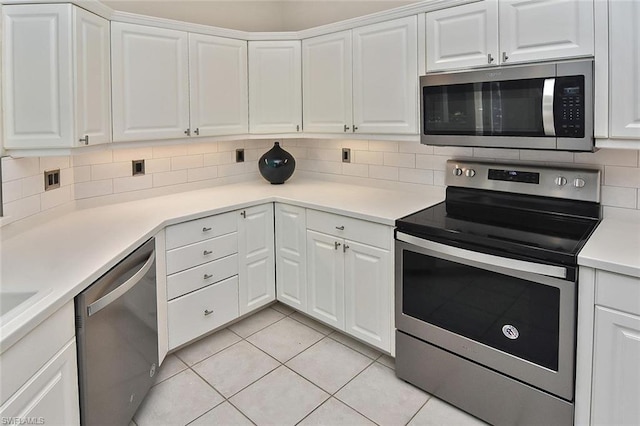 kitchen featuring backsplash, stainless steel appliances, light tile floors, and white cabinetry