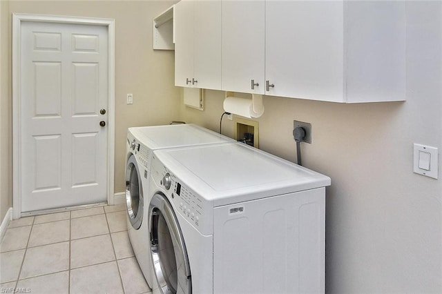 clothes washing area featuring washer hookup, light tile floors, electric dryer hookup, washing machine and clothes dryer, and cabinets