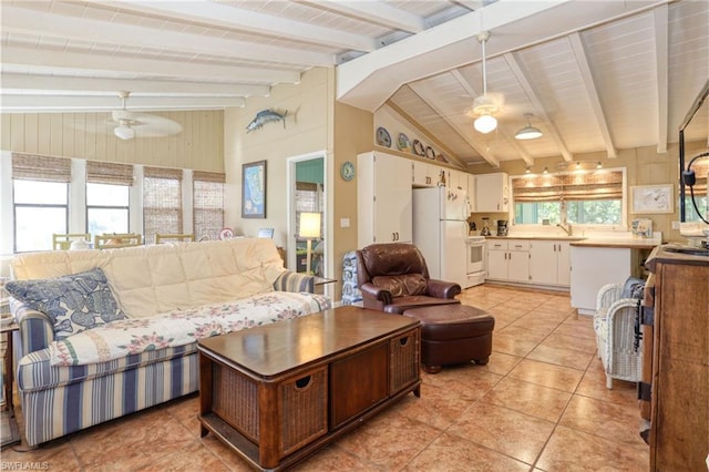 tiled living room featuring lofted ceiling with beams, plenty of natural light, ceiling fan, and sink