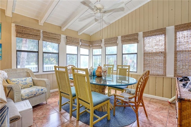 sunroom featuring a healthy amount of sunlight, ceiling fan, and vaulted ceiling with beams