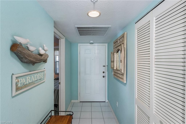 entryway featuring light tile floors and a textured ceiling