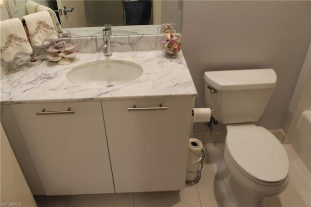 bathroom with oversized vanity, toilet, and tile flooring