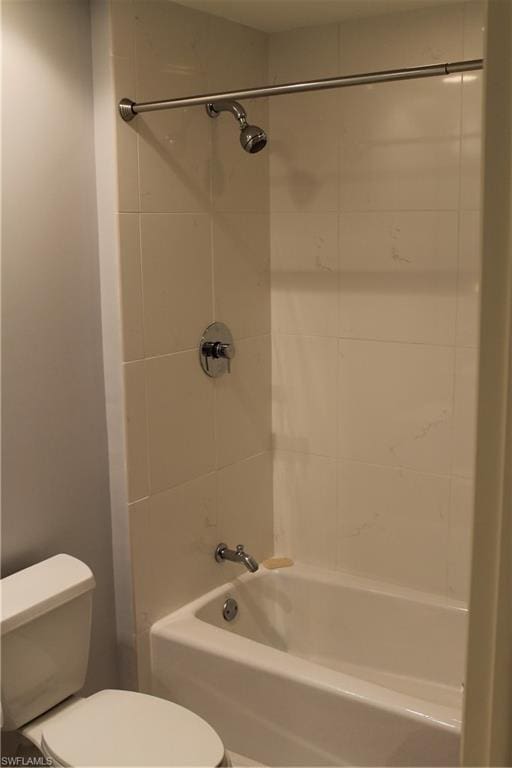 bathroom featuring tiled shower / bath and toilet