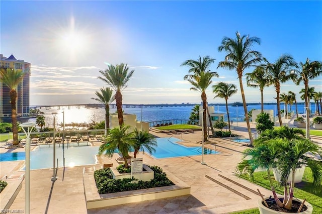 view of pool featuring a water view and a patio