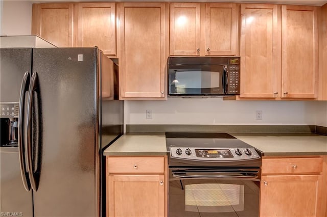 kitchen featuring light brown cabinetry and black appliances