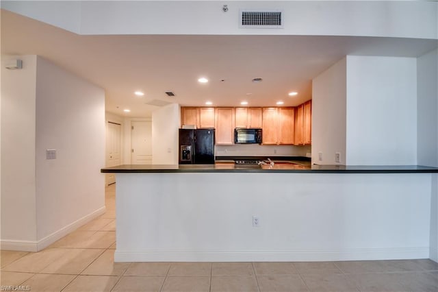 kitchen featuring light tile floors, black appliances, and light brown cabinetry