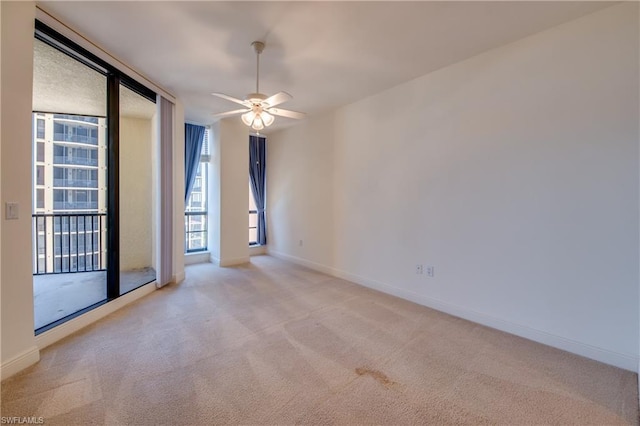 carpeted spare room featuring ceiling fan