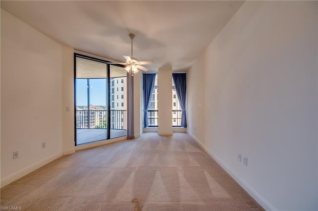 spare room featuring light carpet and ceiling fan