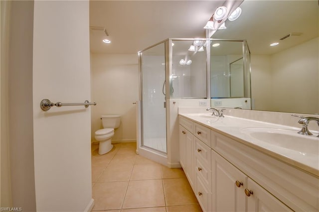 bathroom featuring dual vanity, tile floors, a shower with door, and toilet