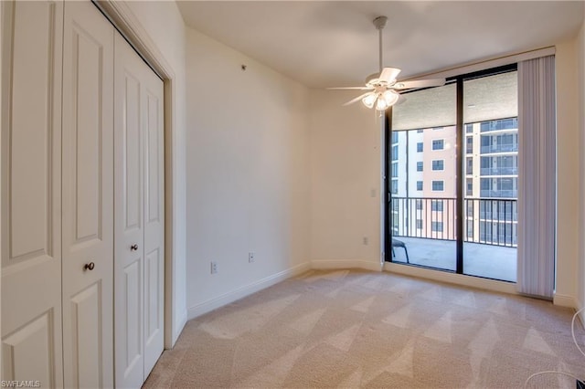 unfurnished bedroom with a closet, light carpet, access to outside, and ceiling fan