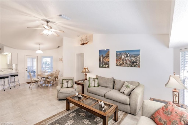 living room with plenty of natural light, light tile floors, vaulted ceiling, and ceiling fan