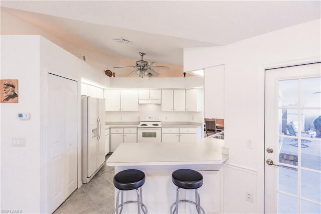 kitchen with light tile floors, stove, ceiling fan, a breakfast bar, and white refrigerator with ice dispenser