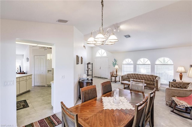 dining space featuring light tile floors, a chandelier, and lofted ceiling