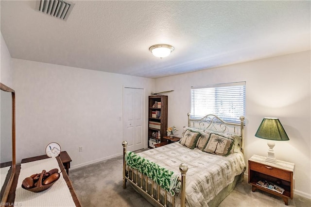 carpeted bedroom with a closet and a textured ceiling