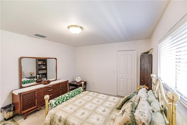 bedroom featuring light colored carpet and a closet