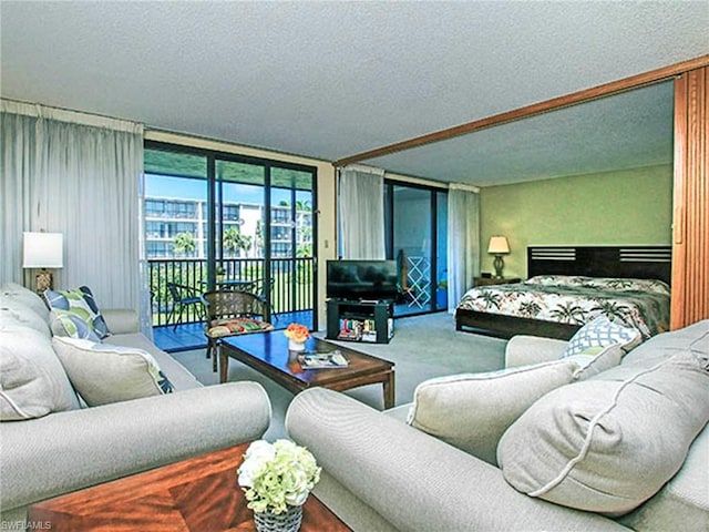 living room with a textured ceiling, carpet floors, and a wall of windows