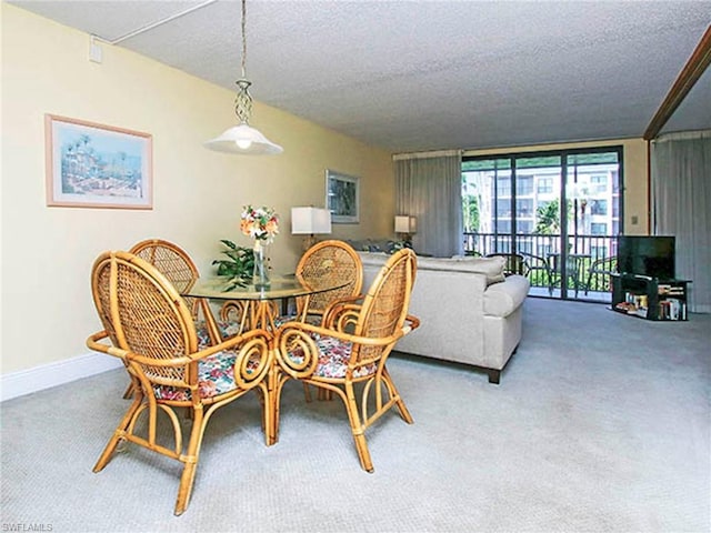 dining space with light carpet, a textured ceiling, and a wall of windows