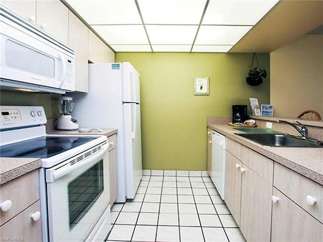 kitchen with white appliances, sink, and light tile floors