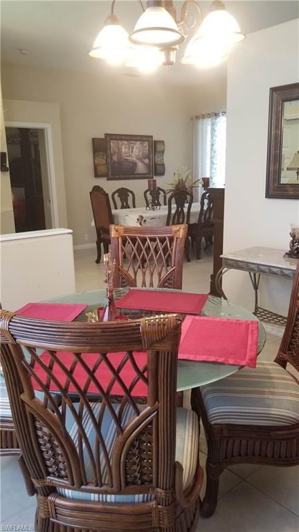 tiled dining room featuring a notable chandelier