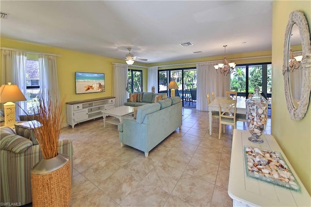 living room with ceiling fan with notable chandelier and light tile floors