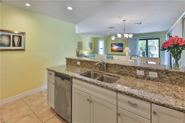 kitchen with an inviting chandelier, white cabinets, stainless steel dishwasher, and light stone countertops