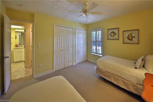 carpeted bedroom with two closets and ceiling fan