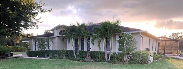 property exterior at dusk with a lawn