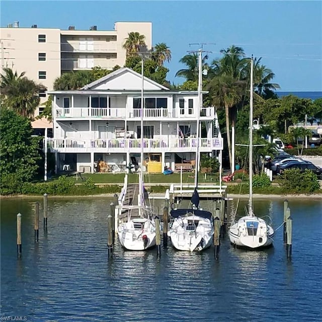 view of dock with a balcony and a water view