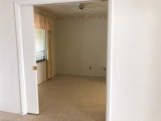 tiled empty room featuring ceiling fan