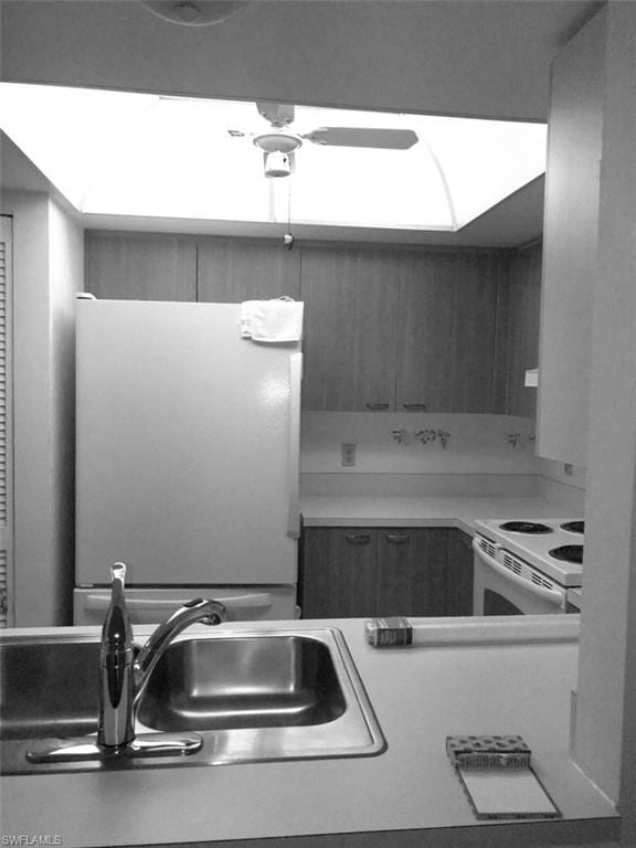 kitchen with ceiling fan, white appliances, and sink