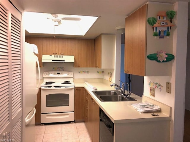 kitchen with a skylight, light tile floors, white appliances, and sink