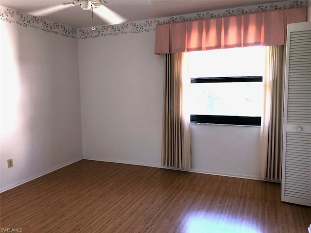 empty room featuring ceiling fan and dark wood-type flooring