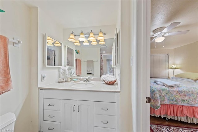 bathroom featuring toilet, large vanity, hardwood / wood-style floors, and ceiling fan