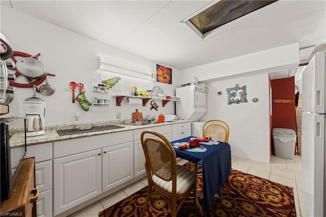 dining room featuring light tile floors, stacked washer and clothes dryer, and sink