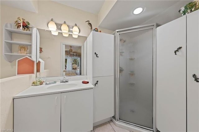 bathroom with a shower with door, tile floors, and large vanity