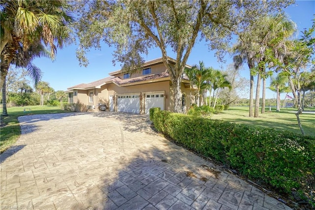 mediterranean / spanish-style house with a front yard and a garage